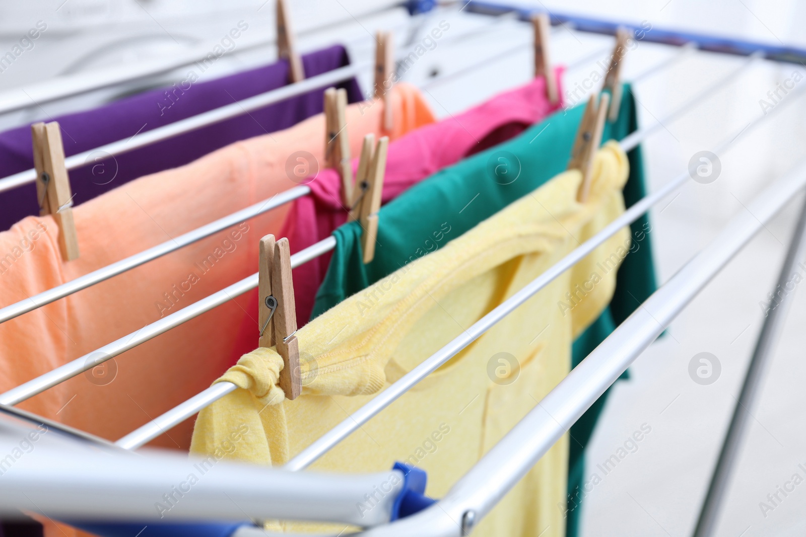 Photo of Clean laundry hanging on drying rack indoors, closeup