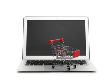 Internet shopping. Laptop with small cart isolated on white