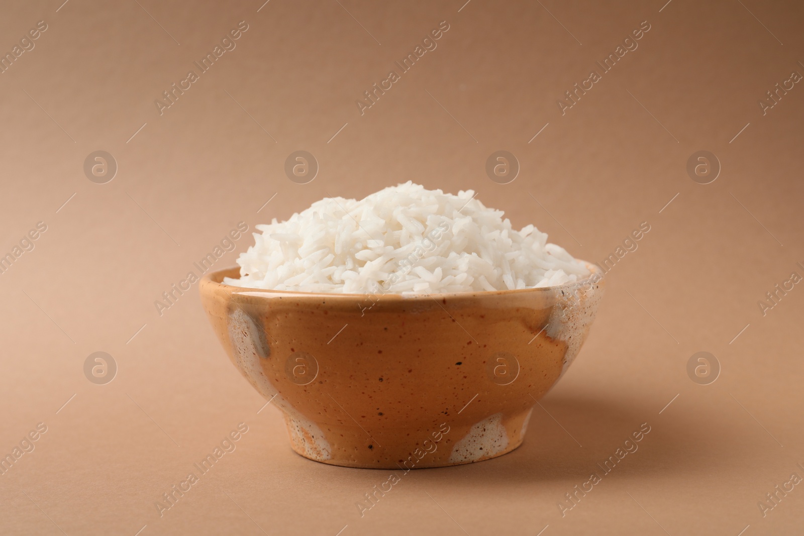 Photo of Bowl of tasty cooked rice on color background