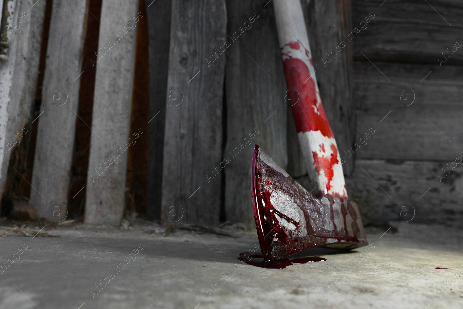 Photo of Axe with blood on floor indoors, closeup. Space for text