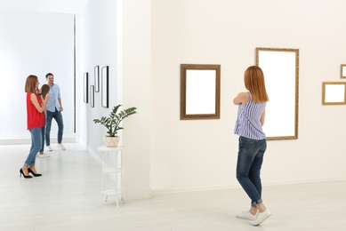 People viewing exposition in modern art gallery