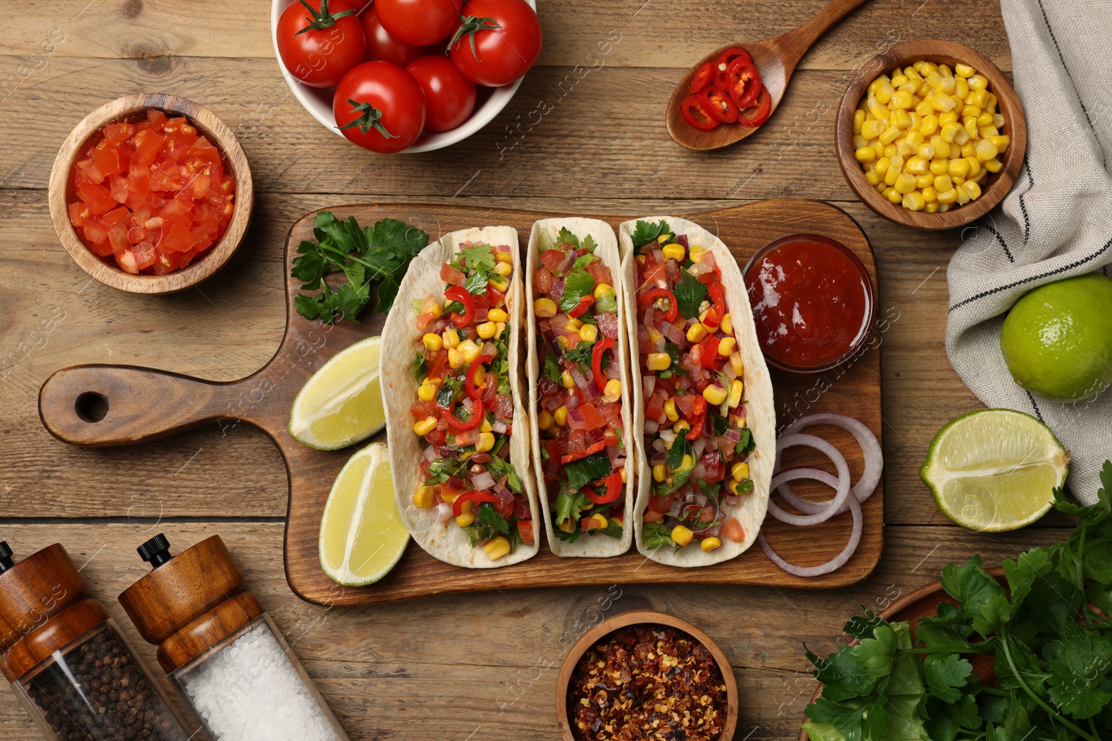 Photo of Tasty tacos with vegetables on wooden table, flat lay