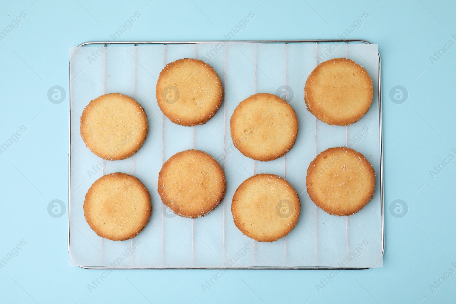 Photo of Tasty sweet sugar cookies on light blue background, top view