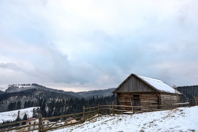 Photo of Winter landscape with old hut on snowy slope