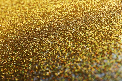 Photo of Closeup view of sparkling golden glitter background