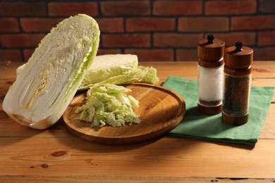 Photo of Fresh Chinese cabbage and spices on wooden table