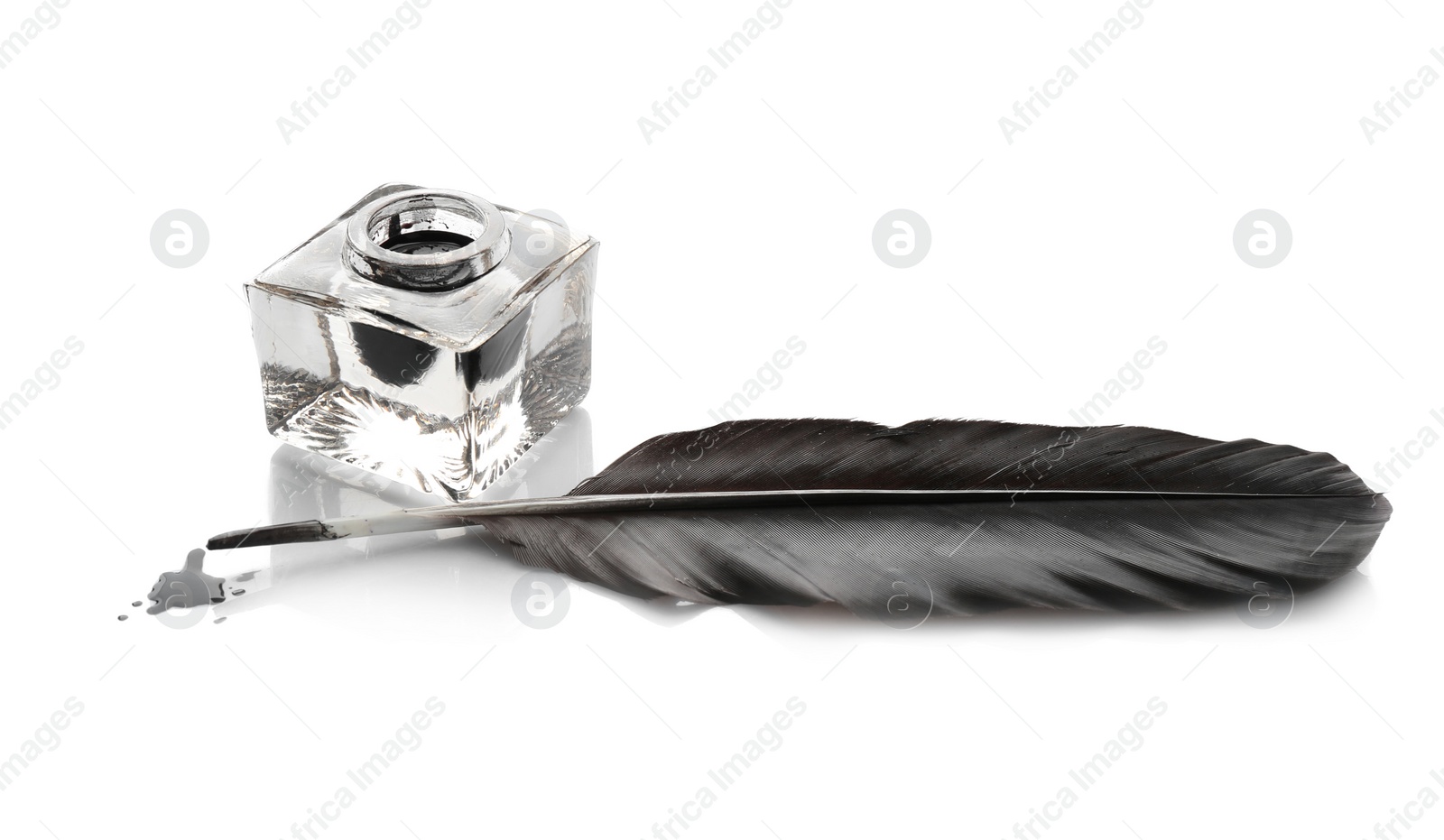 Photo of Feather pen and inkwell on white background