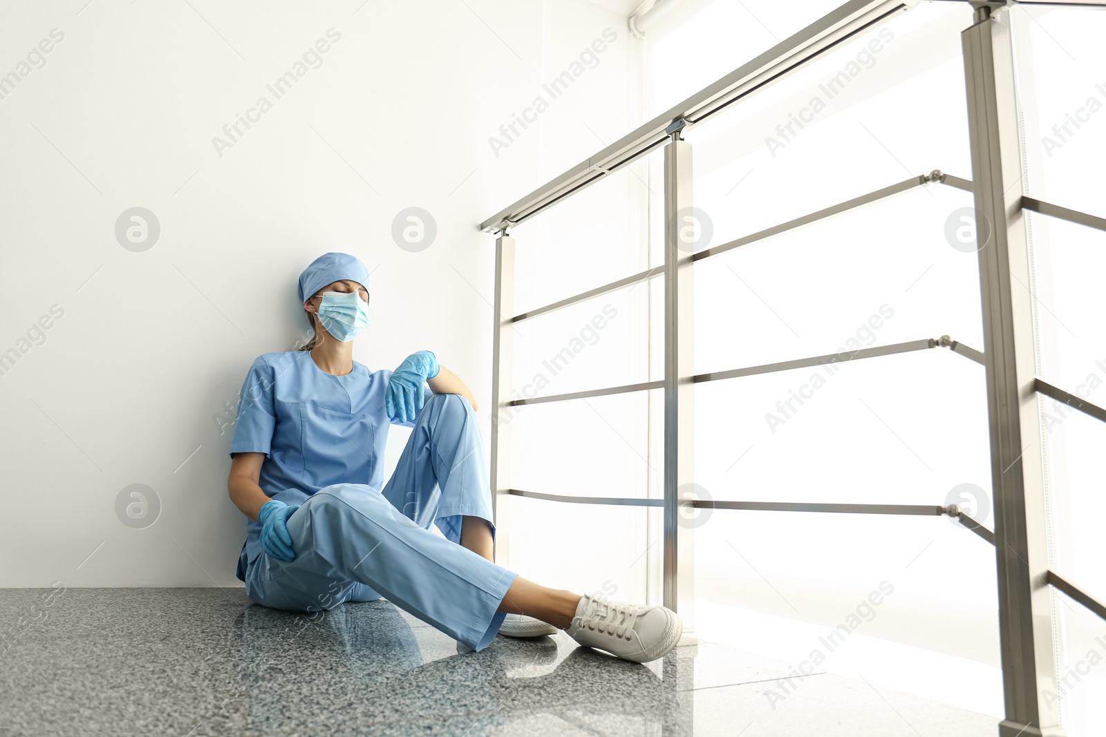 Photo of Exhausted doctor indoors. Stress of health care workers during COVID-19 pandemic