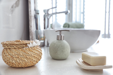 Photo of Soap bar and cotton swabs on table in bathroom