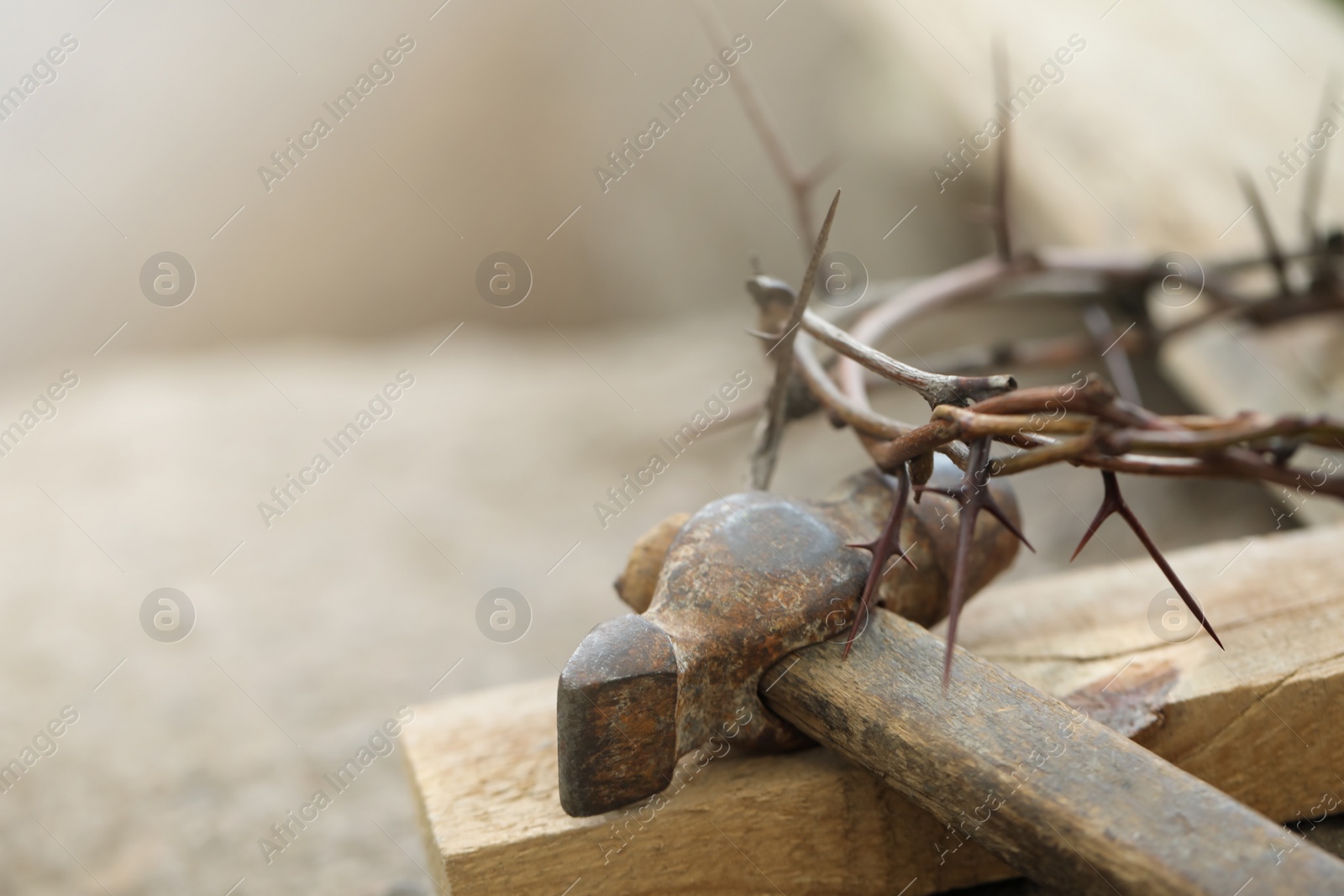Photo of Crown of thorns, wooden plank and hammer on grey background, closeup. Easter attributes