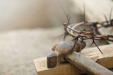 Crown of thorns, wooden plank and hammer on grey background, closeup. Easter attributes