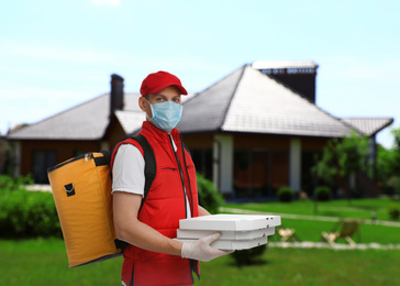 Courier in protective mask and gloves with order outdoors. Delivery service during coronavirus quarantine