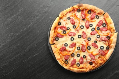 Tasty pizza with cheese, dry smoked sausages, olives and pepper on grey table, top view. Space for text