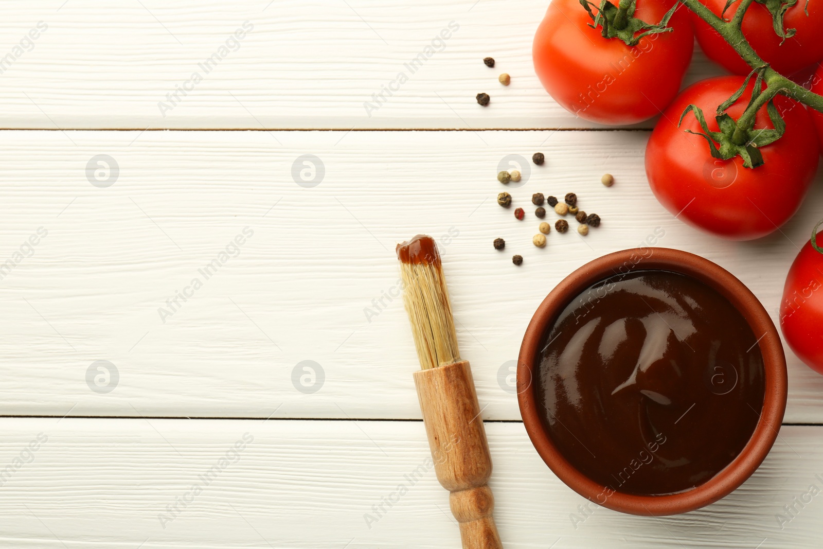 Photo of Flat lay composition with tasty barbeque sauce in bowl on white wooden table. Space for text