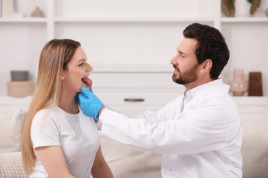 Photo of Doctor in gloves examining woman`s oral cavity indoors
