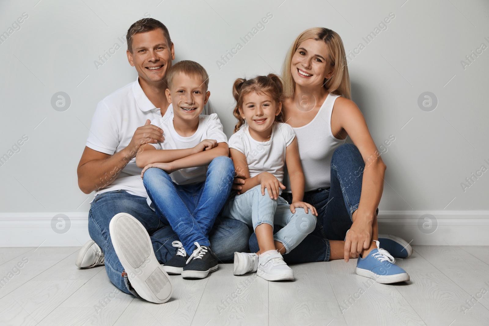 Photo of Happy family with children near grey wall