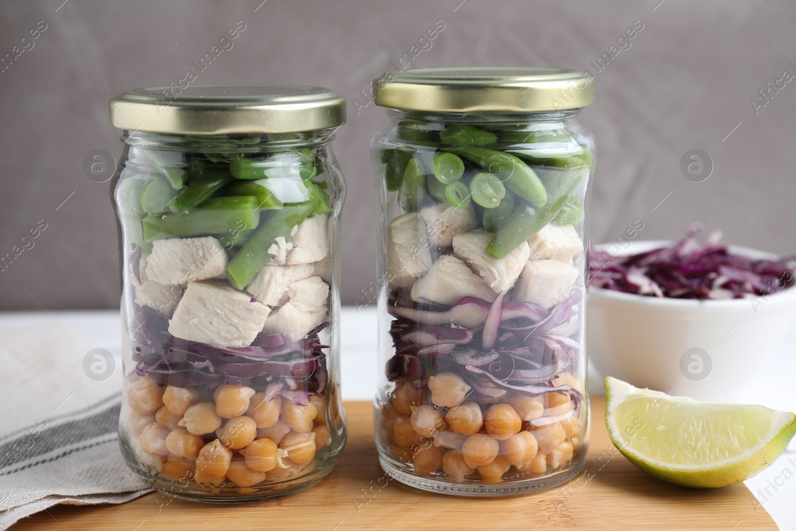 Photo of Glass jars with healthy meal on wooden table