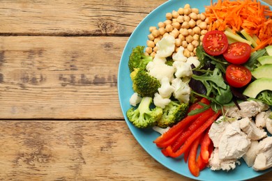 Photo of Balanced diet and healthy foods. Plate with different delicious products on wooden table, top view. Space for text