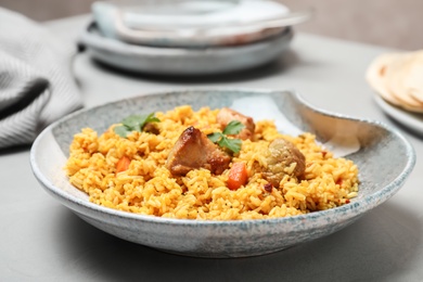 Photo of Plate of tasty rice pilaf with meat on table