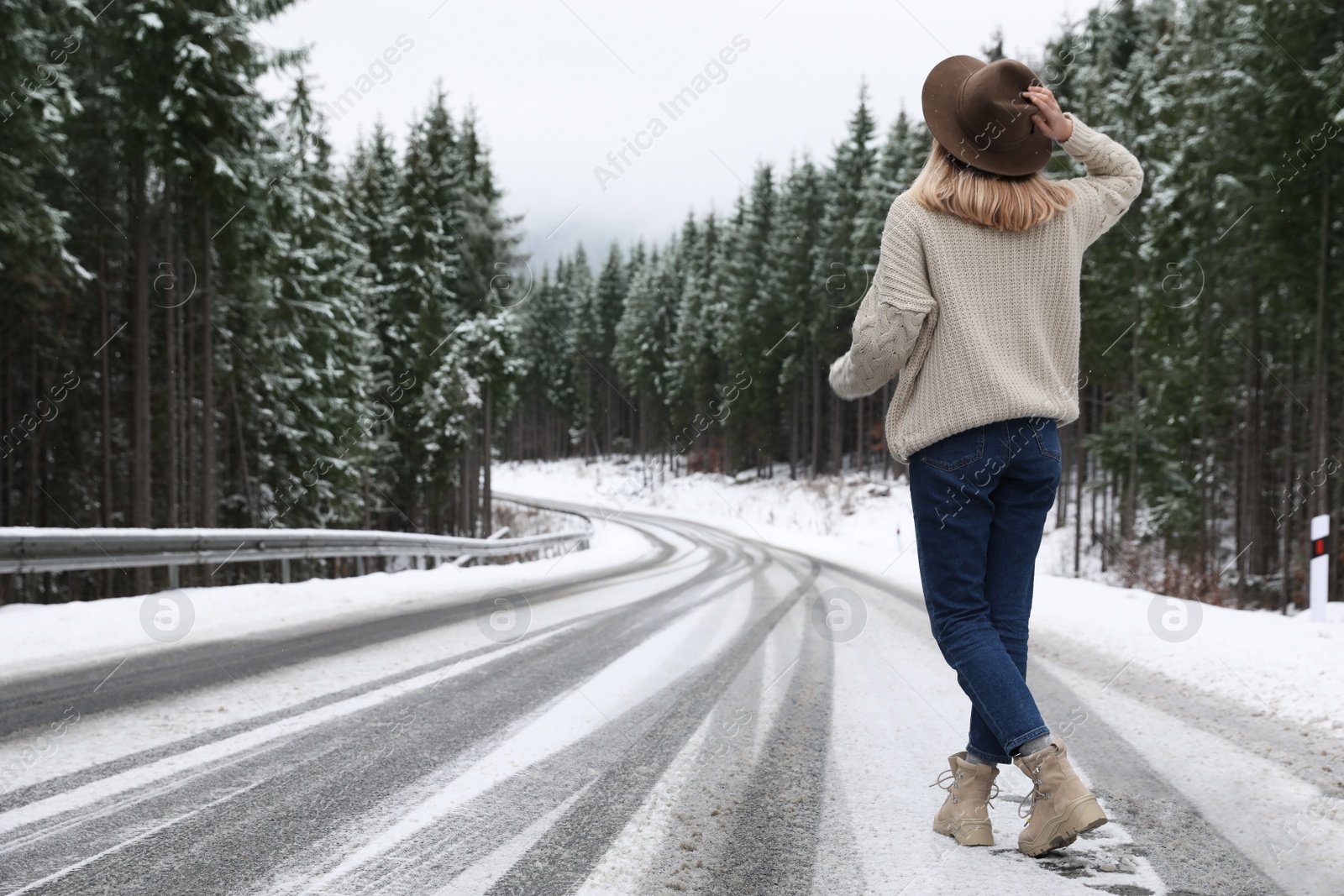 Photo of Young woman walking near snowy forest. Winter vacation