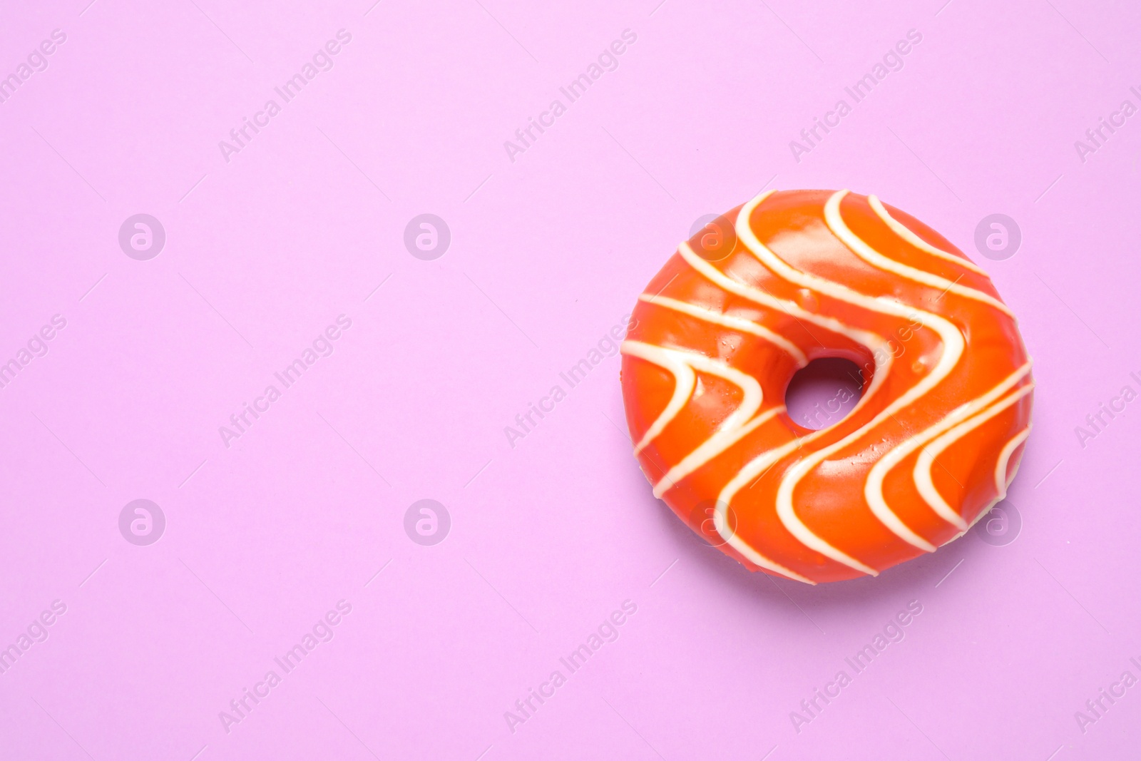 Photo of Delicious glazed donut on lilac background, top view. Space for text