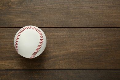 Photo of Baseball ball on wooden table, top view. Space for text