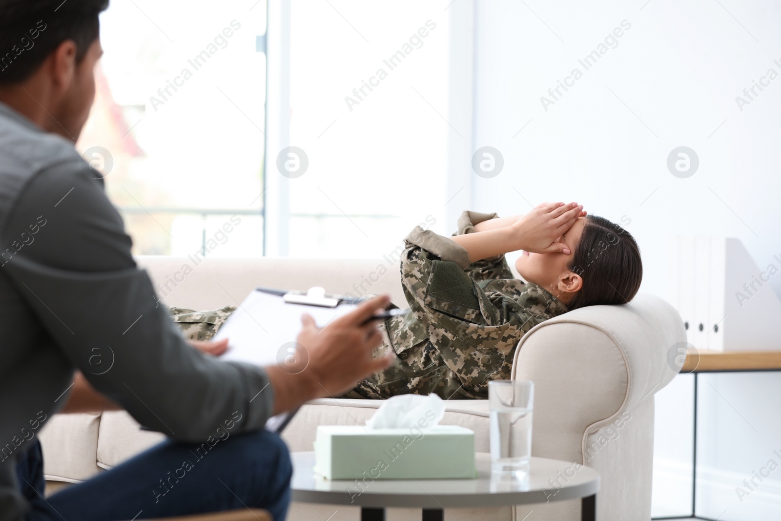 Photo of Psychotherapist working with female military officer in office