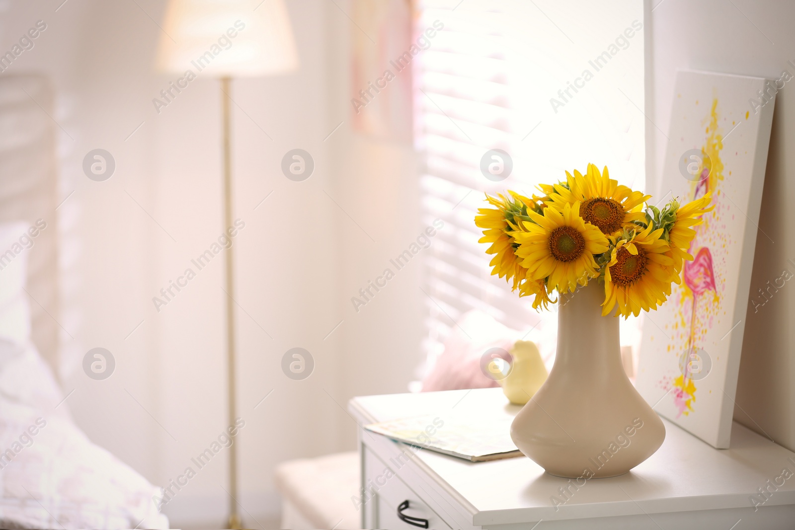 Photo of Beautiful bouquet of sunflowers in vase on white table indoors. Space for text