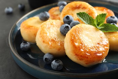 Delicious cottage cheese pancakes with blueberries on plate, closeup