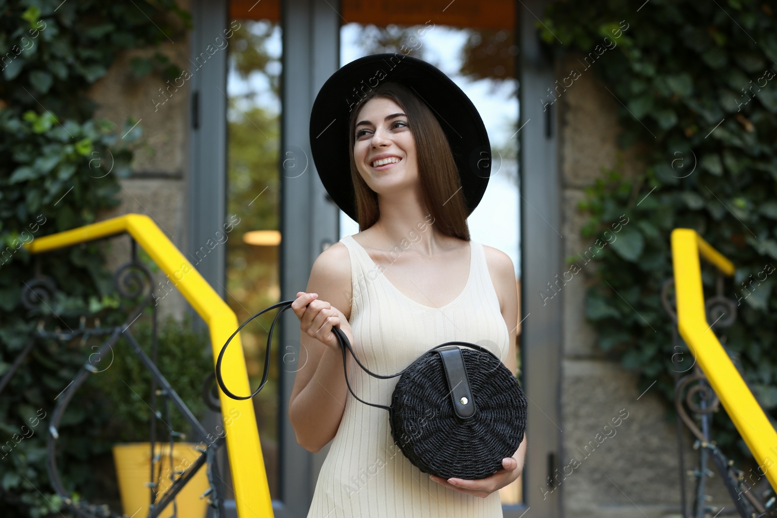 Photo of Beautiful young woman with stylish handbag outdoors on summer day