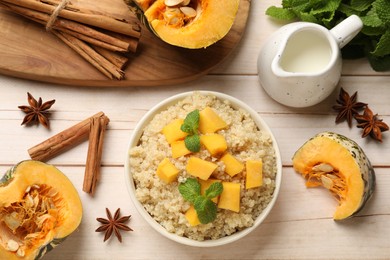 Photo of Flat lay composition with bowl of tasty quinoa porridge and pumpkin on light wooden table