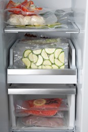 Photo of Vacuum bags with different products in fridge. Food storage