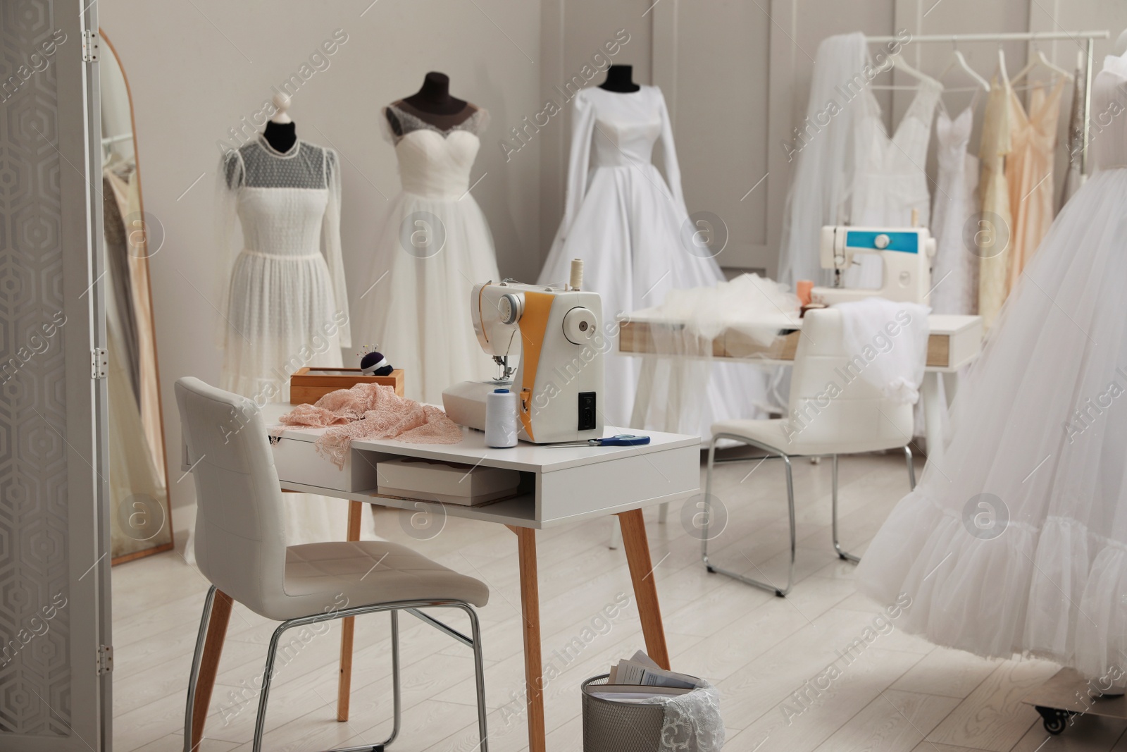 Photo of Dressmaking workshop interior with wedding dresses and equipment