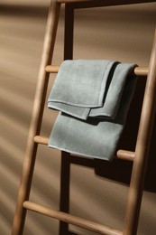 Photo of Terry towel on wooden decorative ladder near beige wall