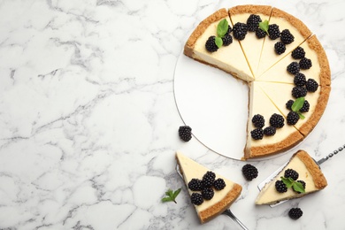 Photo of Sliced delicious cheesecake with blackberries on white marble background, flat lay. Space for text