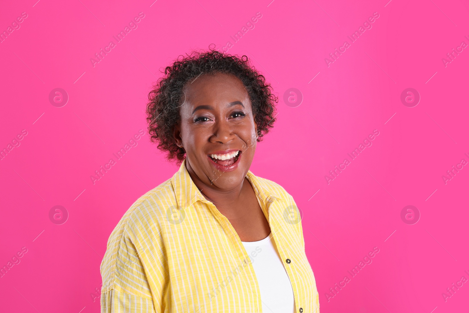 Photo of Portrait of happy African-American woman on pink background