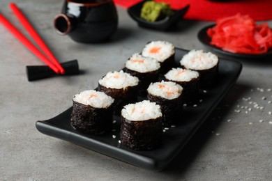 Photo of Tasty sushi rolls served on grey table