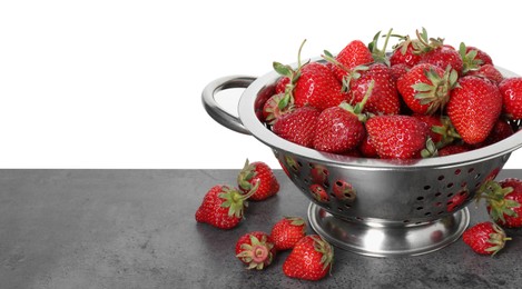 Photo of Metal colander with fresh strawberries on grey table against white background. Space for text