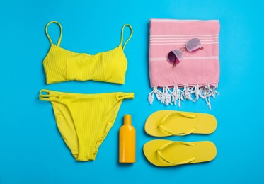 Flat lay composition with beach objects on light blue background