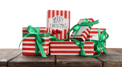 Many Christmas gifts on wooden table against white background