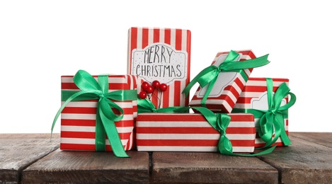 Photo of Many Christmas gifts on wooden table against white background