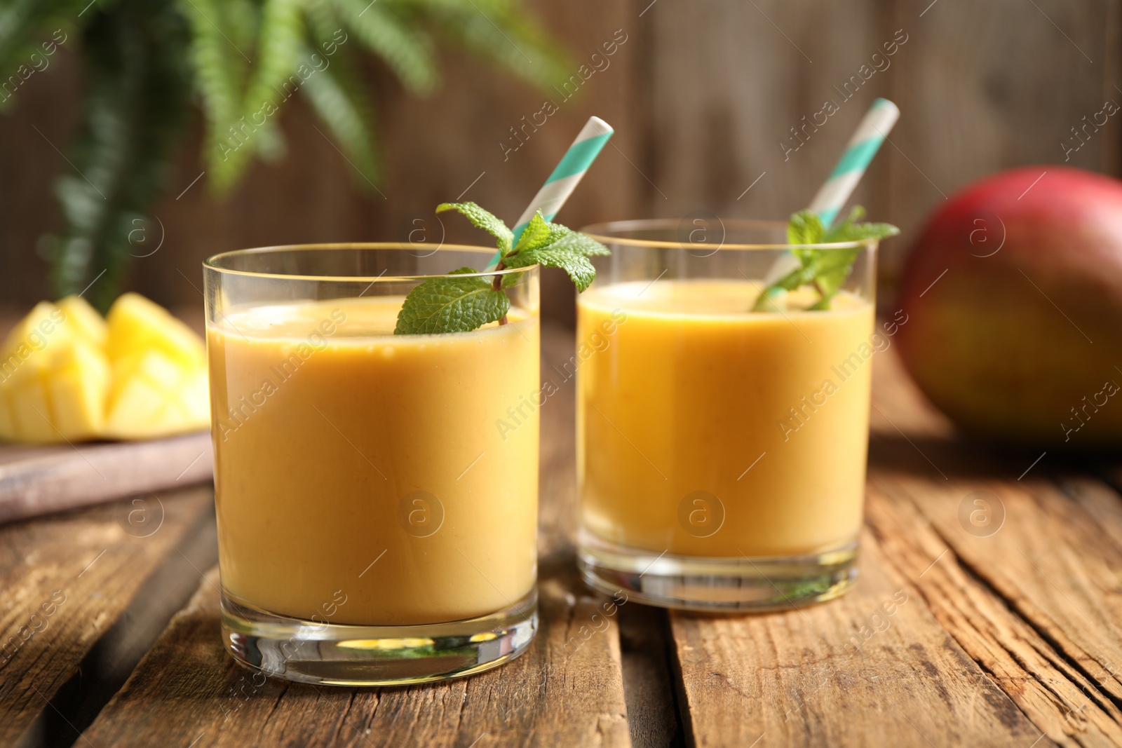 Photo of Fresh delicious mango drink on wooden table