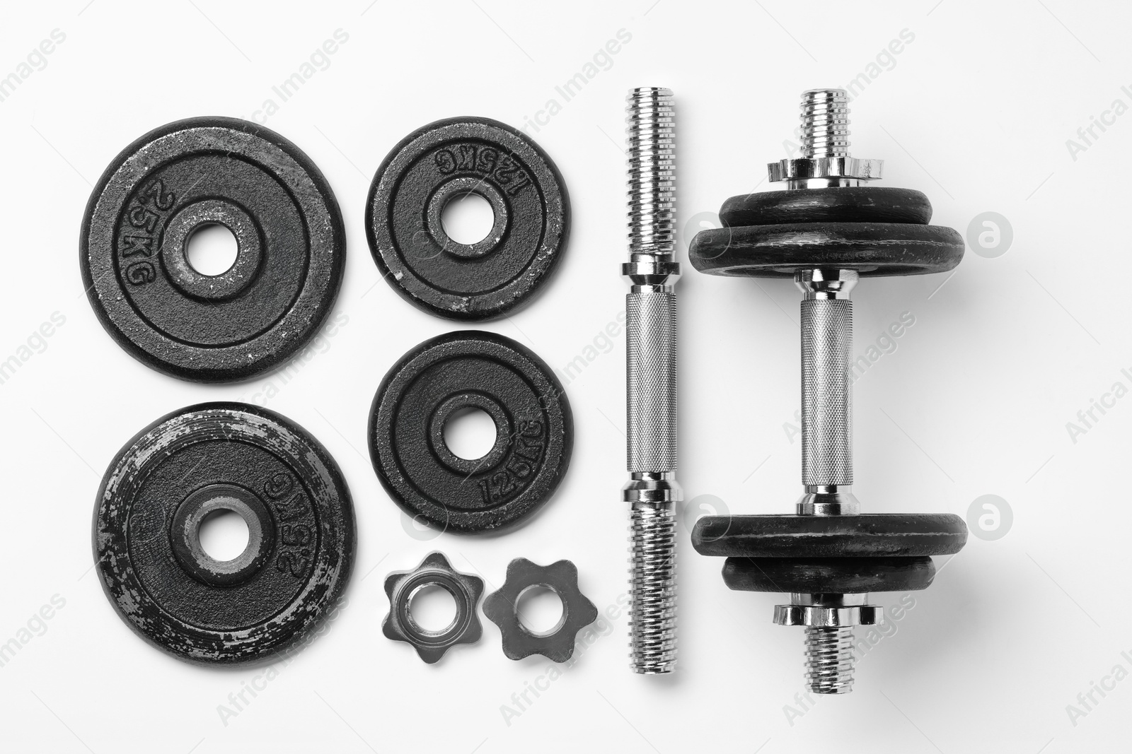 Photo of Metal dumbbell and parts on white background, top view. Sports equipment