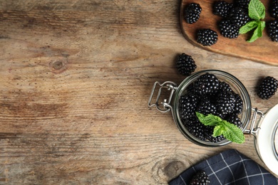 Photo of Flat lay composition with tasty blackberries and space for text on wooden table