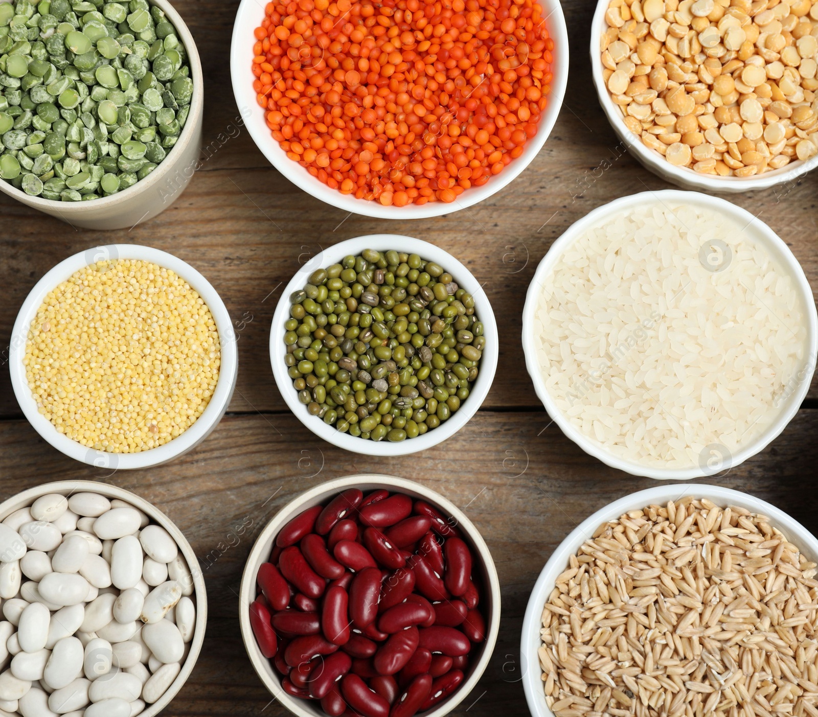 Photo of Different grains and cereals on wooden table, flat lay