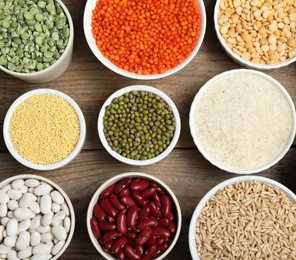 Photo of Different grains and cereals on wooden table, flat lay