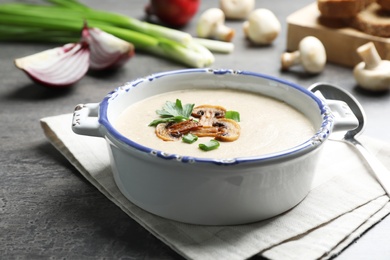 Photo of Bowl of fresh homemade mushroom soup on gray table