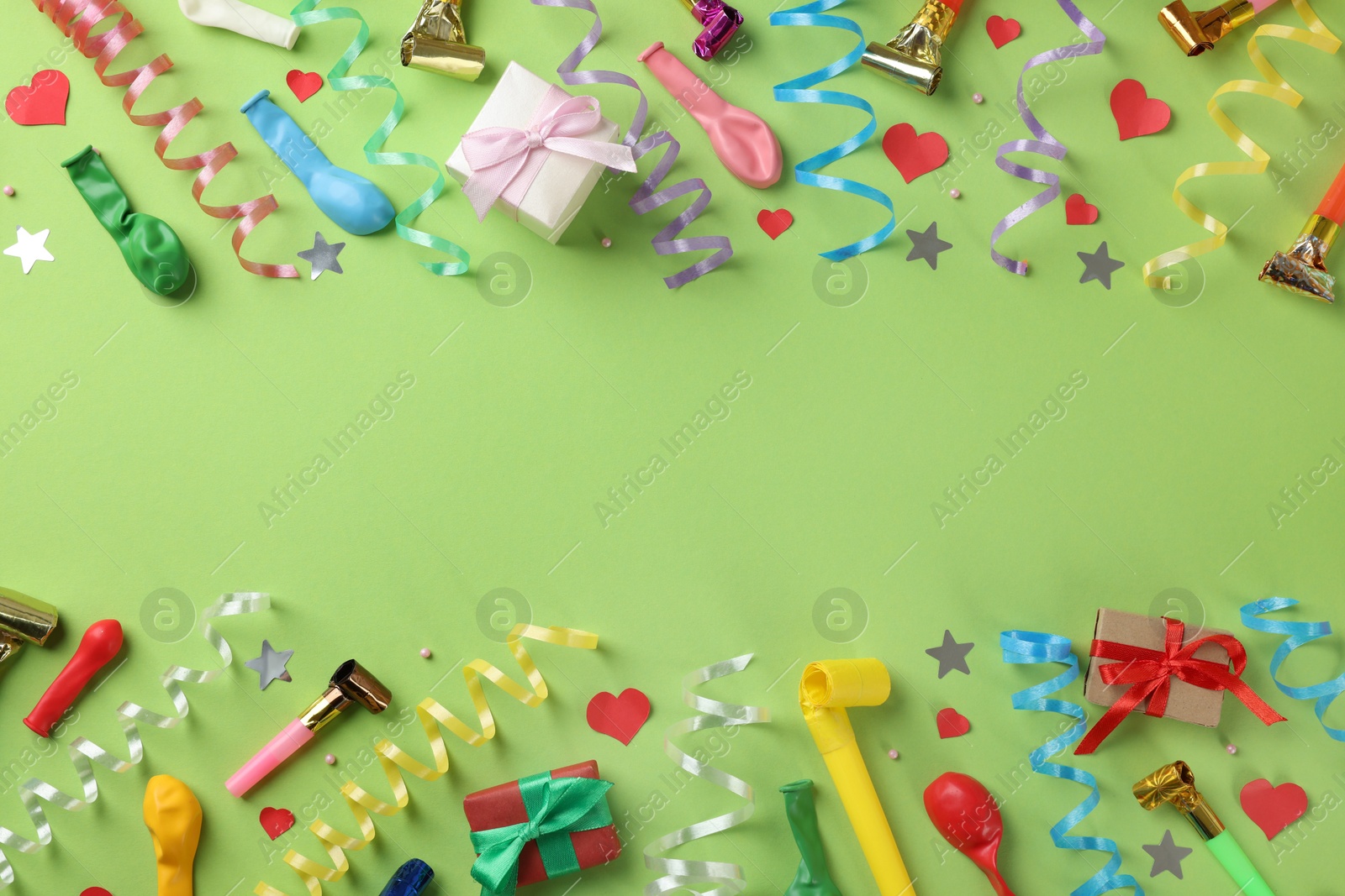 Photo of Flat lay composition with colorful serpentine streamers and confetti on green background, space for text