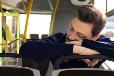 Photo of Tired man sleeping while sitting in public transport, closeup