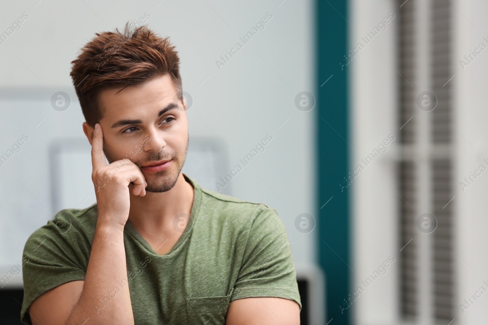 Photo of Portrait of handsome young man in room. Space for text